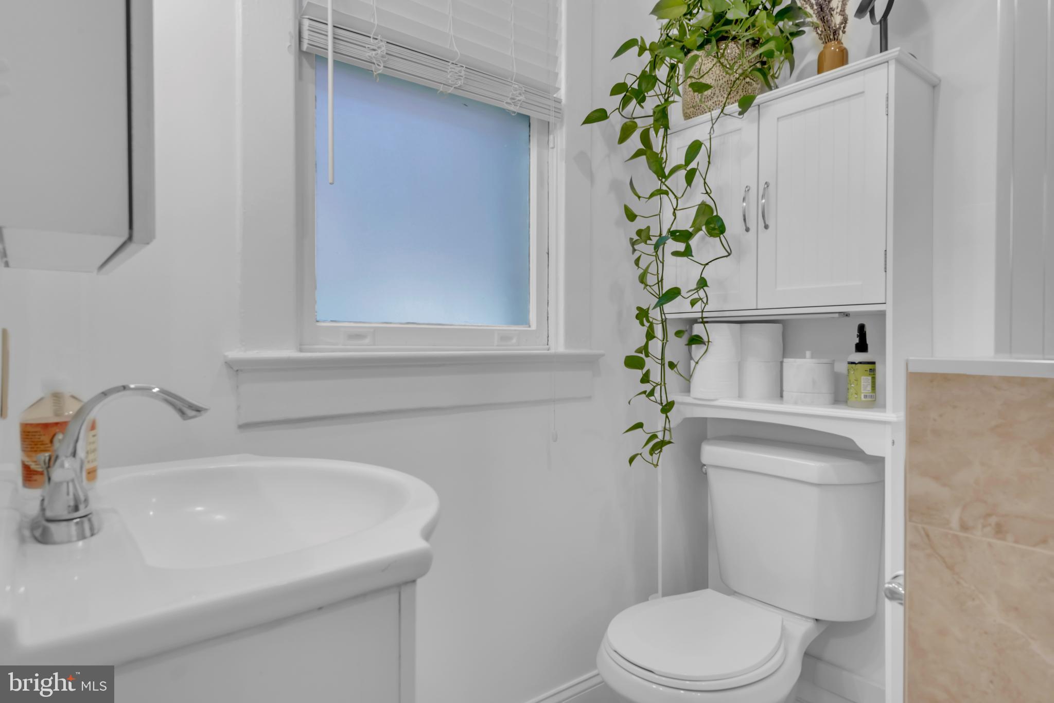 3020 Porter Street Northwest, Unit 103 Washington, DC 20008 - Photo 25 of 30 a bathroom with a sink a toilet and a mirror