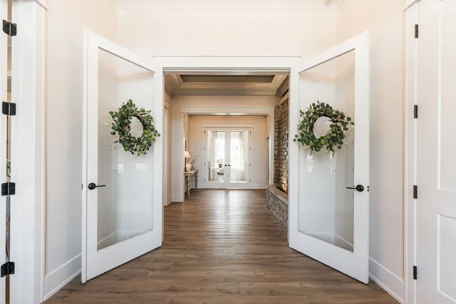 a view of a hallway with wooden floor and a glass door