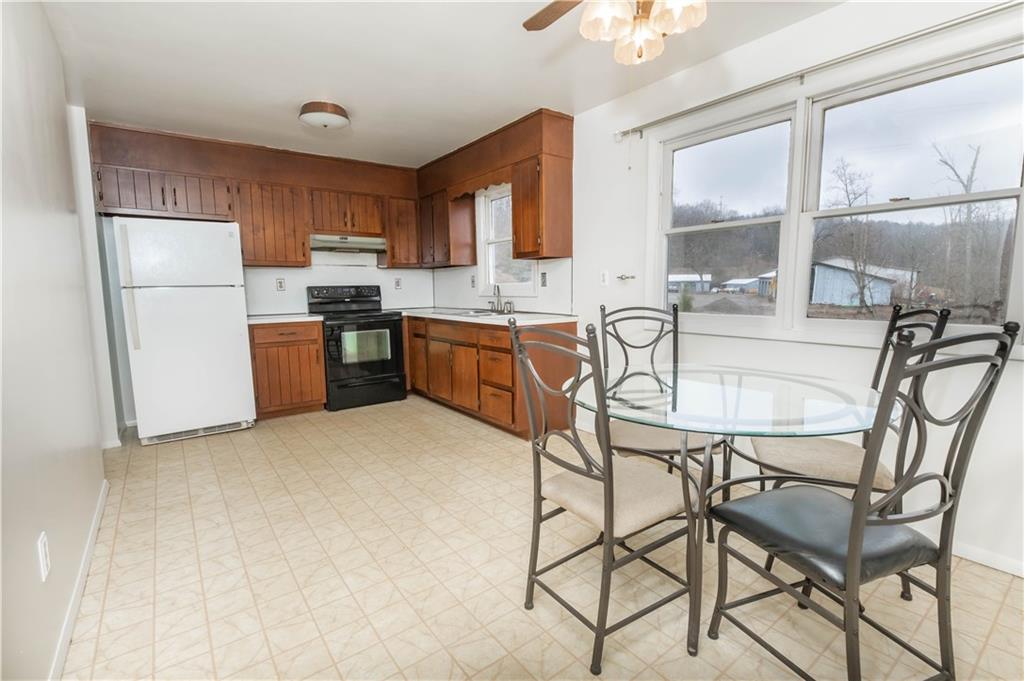 246 King Hill Road Indiana, PA 15701 - Photo 6 of 24 a kitchen with stainless steel appliances granite countertop a stove a refrigerator a sink a dining table and chairs with wooden floor