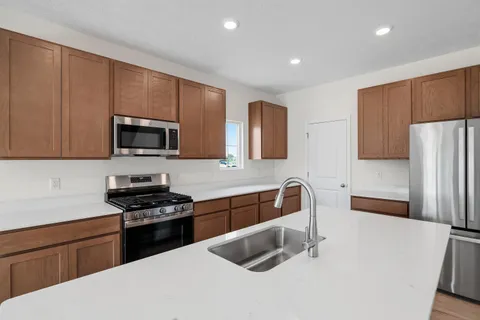 a kitchen with stainless steel appliances a sink stove and refrigerator