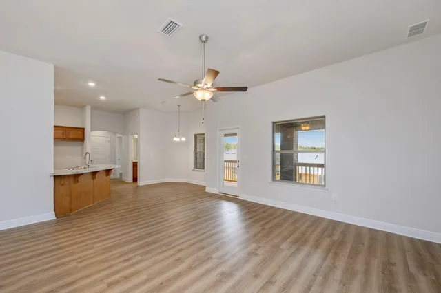 a view of an empty room with window and wooden floor