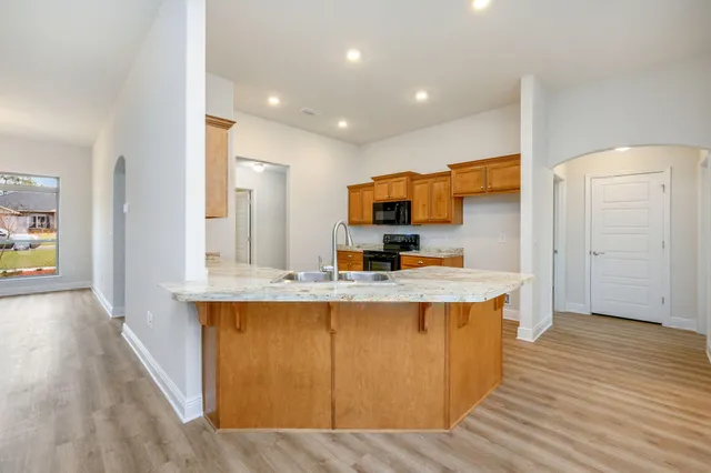a kitchen with kitchen island a sink and a stove top oven