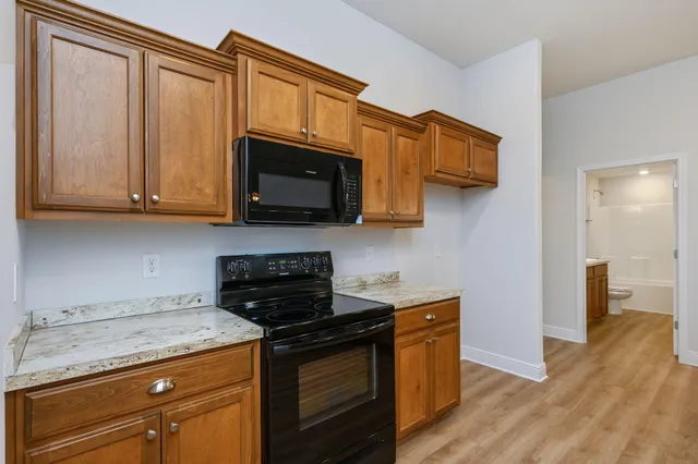 a kitchen with stainless steel appliances granite countertop a stove a sink and a microwave