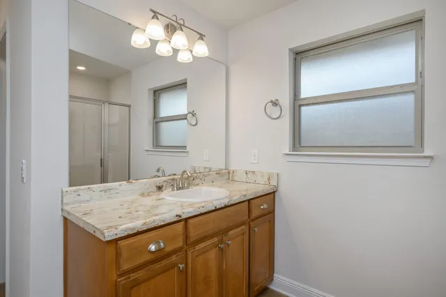 a bathroom with a granite countertop sink and a mirror