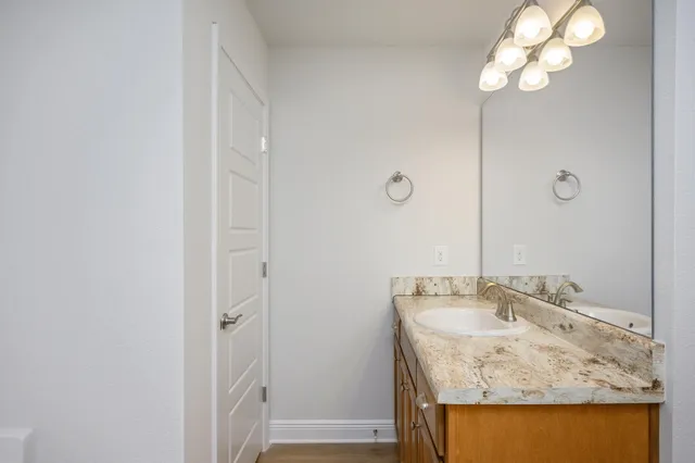 a bathroom with a granite countertop sink and a mirror