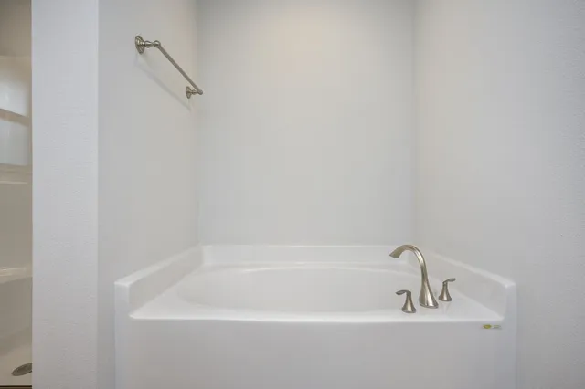 a white bath tub sitting next to a white sink and vanity