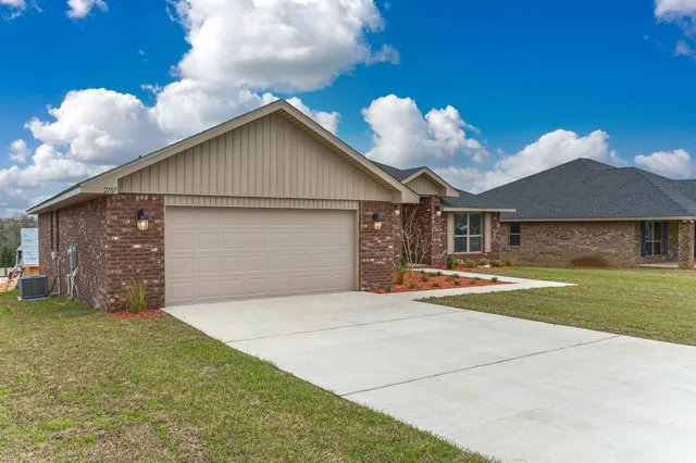 a view of a house with a yard and a garage