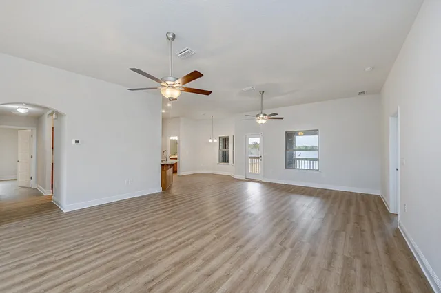 a view of a livingroom with a ceiling fan window and wooden floor