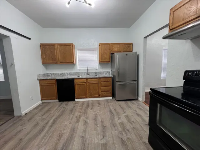 a kitchen with stainless steel appliances granite countertop a refrigerator a stove a sink and a refrigerator