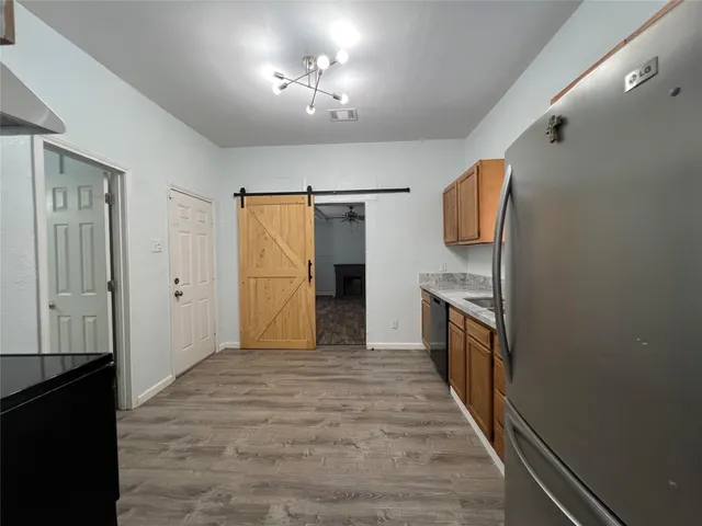 a view of a kitchen with a sink and a refrigerator