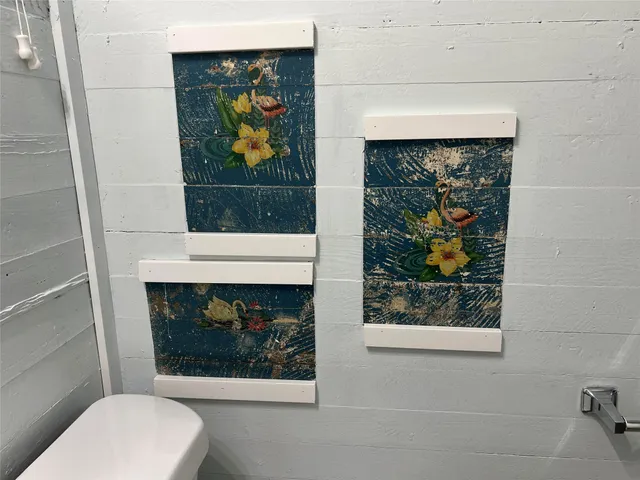 a bathroom with a toilet and a painting on the wall