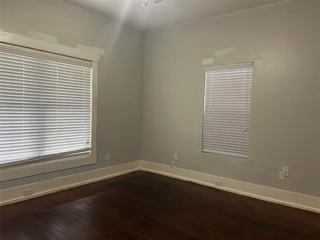 an empty room with wooden floor and a window
