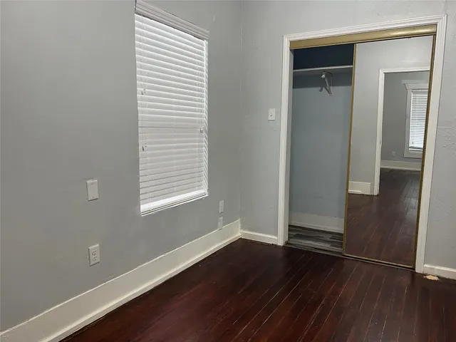 an empty room with wooden floor and closet