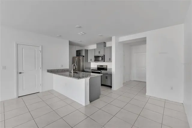 a kitchen with stainless steel appliances granite countertop a sink stove and cabinets