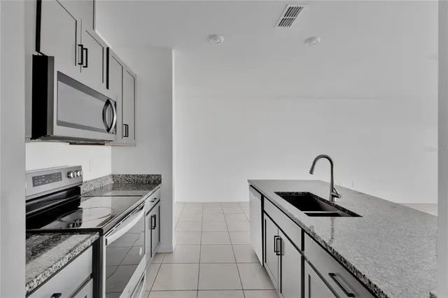 a kitchen with stainless steel appliances granite countertop a sink and a stove