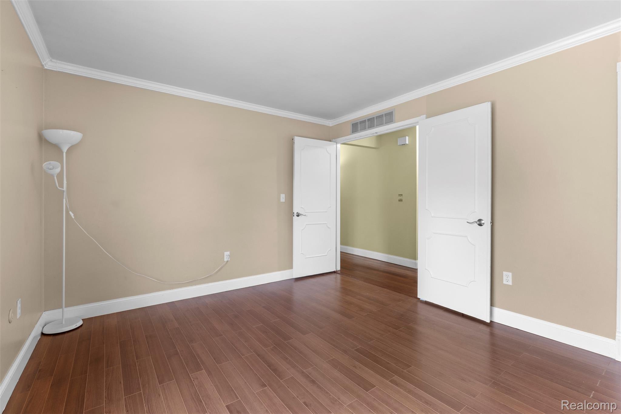 22530 Sheridan Road Novi, MI 48375 - Photo 14 of 50 Unfurnished bedroom featuring crown molding and dark wood-style flooring