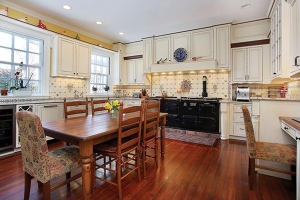 15 Kennard Road Brookline, MA 02445 - Photo 5 of 13 a kitchen with stainless steel appliances granite countertop a stove a refrigerator a sink a dining table and chairs with wooden floor