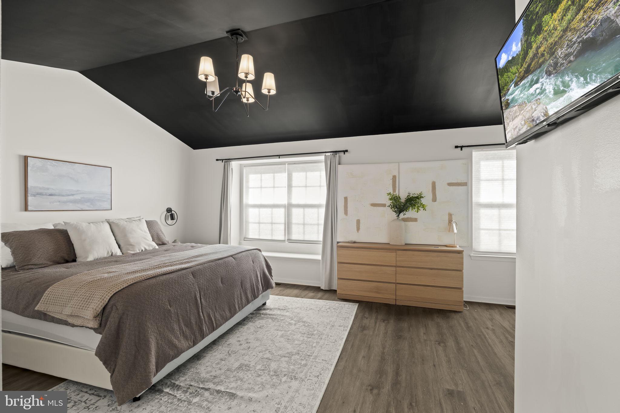 103 Oak Ridge Drive Mount Royal, NJ 08061 - Photo 22 of 34 a spacious bedroom with a bed and a chandelier