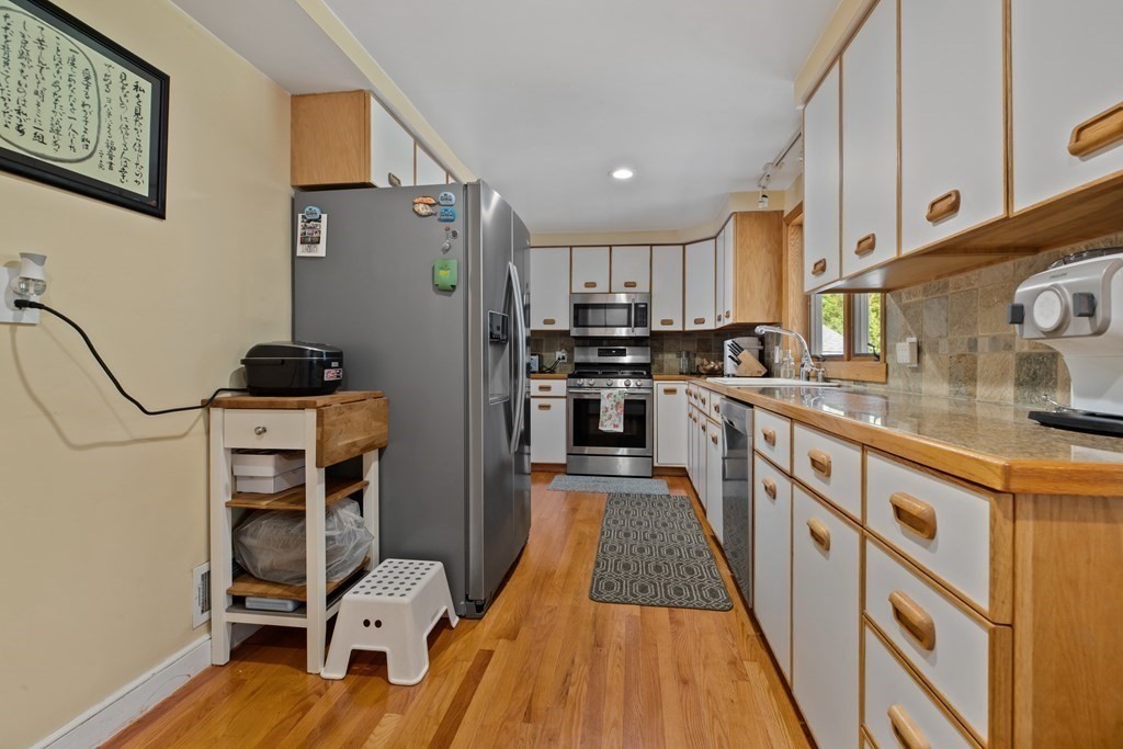 19 Manor Avenue Natick, MA 01760 - Photo 7 of 29 a kitchen with stainless steel appliances a stove a sink a refrigerator cabinets and a dining table