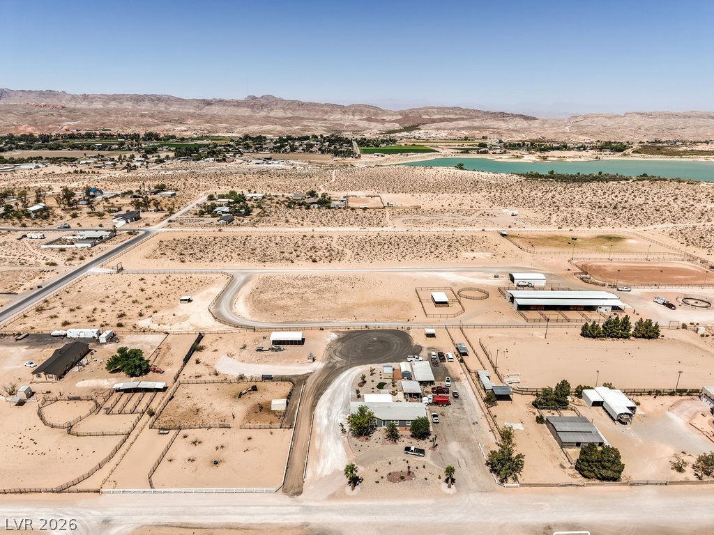 4375 Pinwheel Street Logandale, NV 89021 - Photo 44 of 52 An aerial perspective reveals a sprawling desert landscape with scattered homes and equestrian facilities near the reservoir.