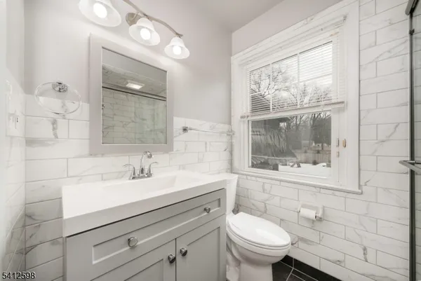 a bathroom with a sink vanity mirror and toilet