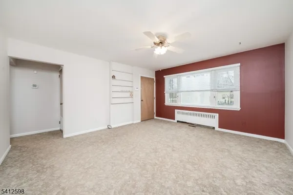 an empty room with windows and ceiling fan
