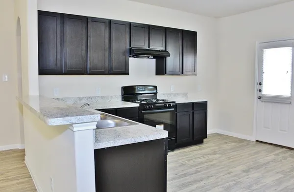 a kitchen with granite countertop wooden cabinets and black appliances