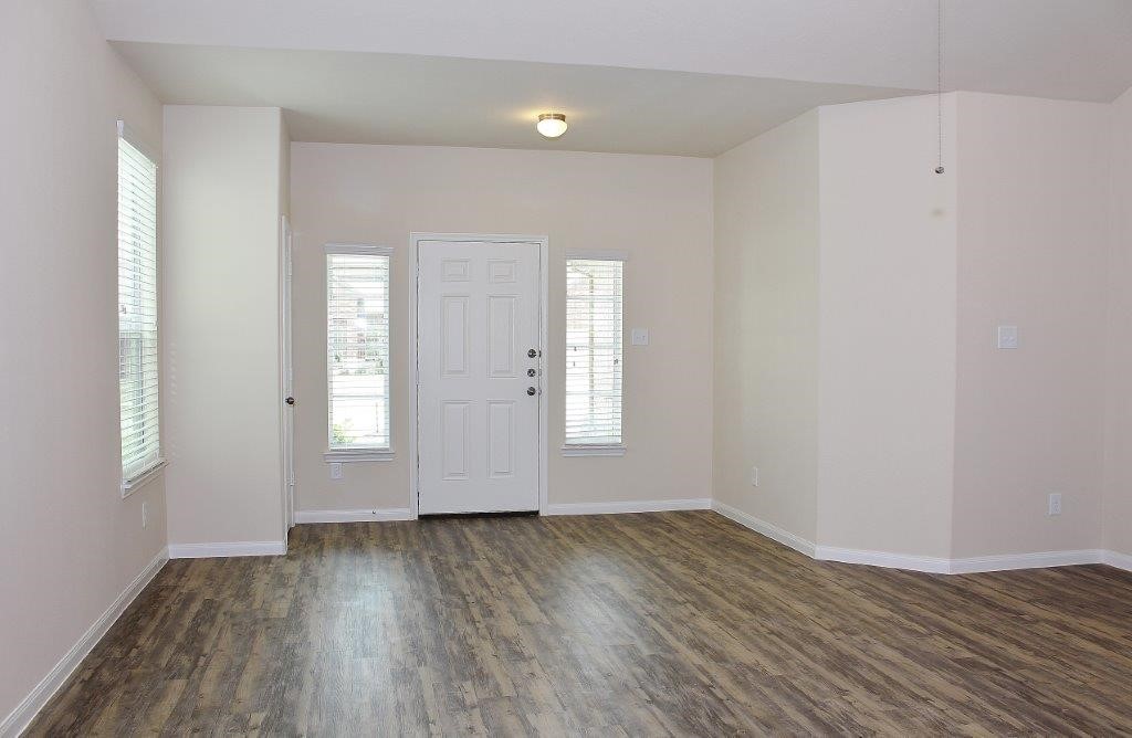 12434 Gemma Lane Houston, TX 77044 - Photo 9 of 15 an empty room with wooden floor and windows