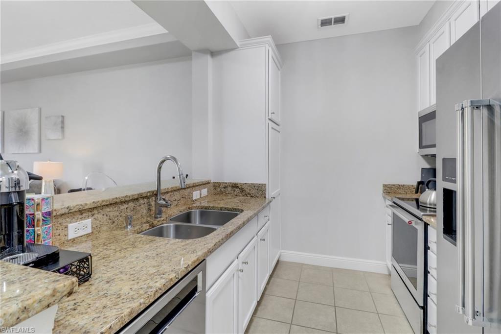 8011 Via Monte Carlo Way, Unit 2208 Estero, FL 33928 - Photo 6 of 34 a kitchen with a sink stove and refrigerator