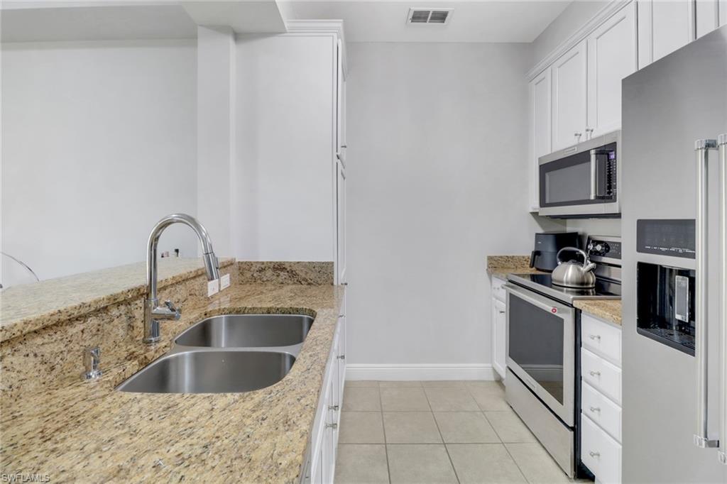 8011 Via Monte Carlo Way, Unit 2208 Estero, FL 33928 - Photo 7 of 34 a kitchen with stainless steel appliances granite countertop a sink and a stove