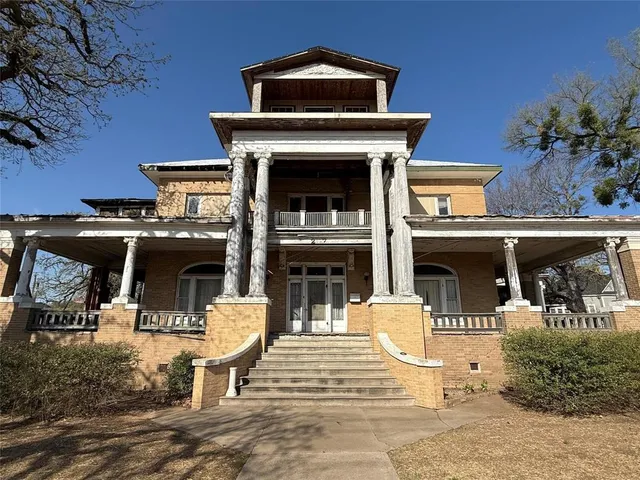 a view of a patio with table and chairs potted plants and a fireplace