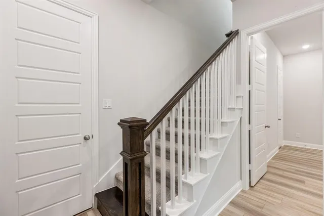 a view of staircase with wooden floor and white walls