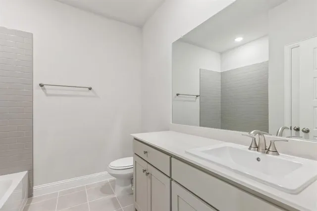 a bathroom with a granite countertop sink a toilet and a mirror