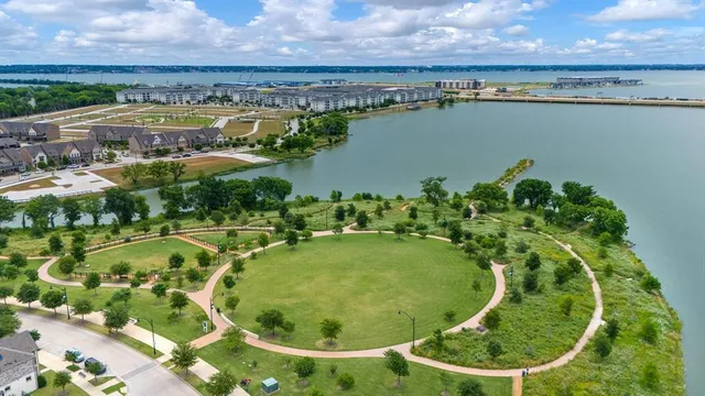 an aerial view of residential houses with outdoor space and lake view