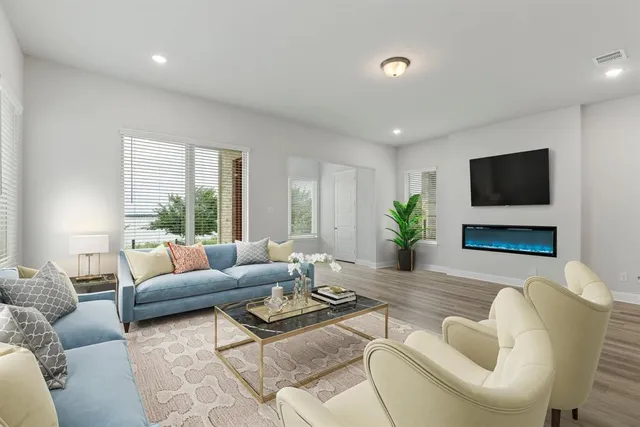 a living room with furniture a flat screen tv and a large window