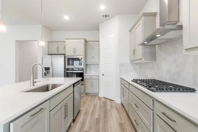 a kitchen with stainless steel appliances granite countertop a sink stove and refrigerator