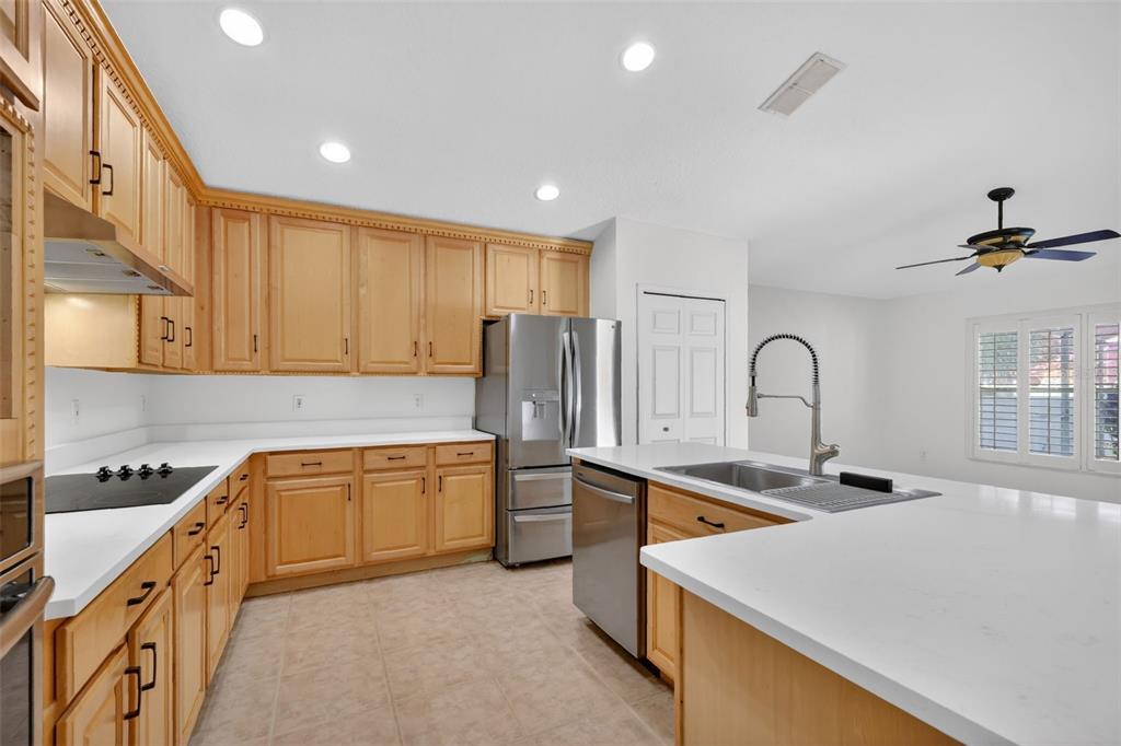 729 Strihal Loop Oakland, FL 34787 - Photo 20 of 49 a kitchen with stainless steel appliances granite countertop a sink a stove and a refrigerator