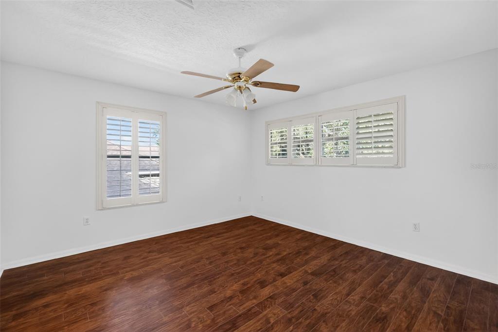 729 Strihal Loop Oakland, FL 34787 - Photo 38 of 49 an empty room with wooden floor ceiling fan and windows