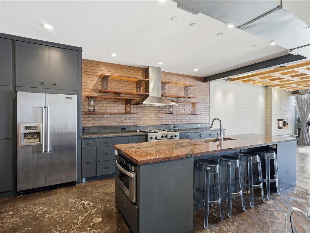 511 North Akard Street, Unit 1505 Dallas, TX 75201 - Photo 23 of 39 This kitchen truly stands out with the brick accent wall and SS appliances.
