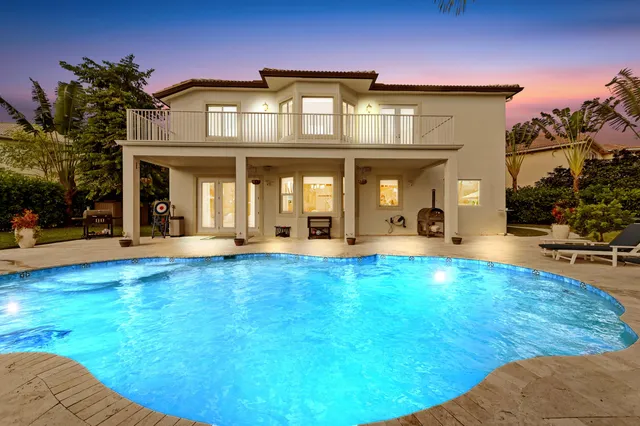 an aerial view of residential houses with outdoor space and trees