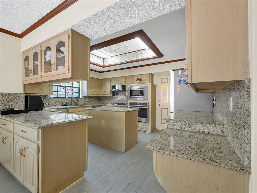 10211 Shadow Way Dallas, TX 75243 - Photo 20 of 39 a kitchen with stainless steel appliances granite countertop a sink and cabinets