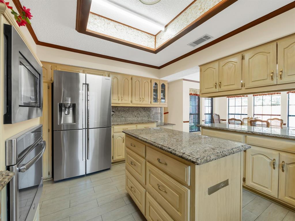 10211 Shadow Way Dallas, TX 75243 - Photo 22 of 39 a kitchen with stainless steel appliances granite countertop a refrigerator a sink dishwasher and white cabinets with wooden floor