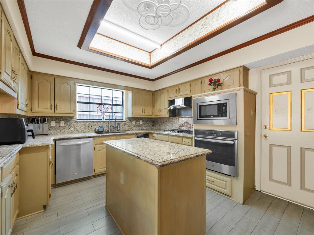10211 Shadow Way Dallas, TX 75243 - Photo 24 of 39 a kitchen with stainless steel appliances granite countertop a stove sink and microwave