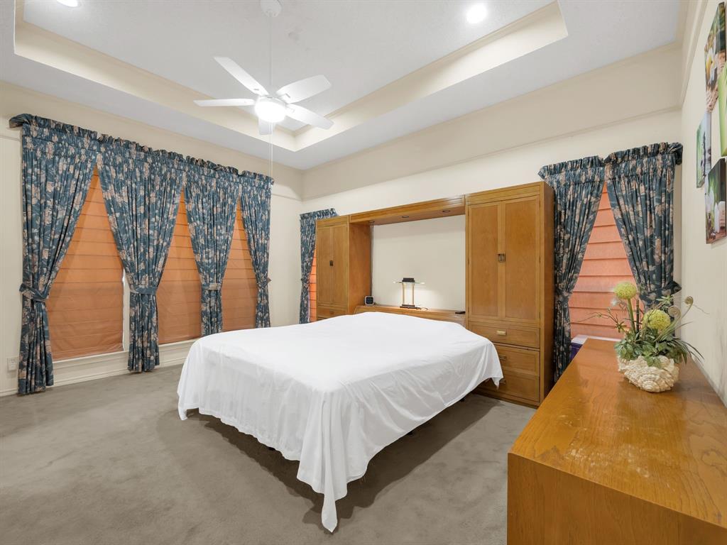 10211 Shadow Way Dallas, TX 75243 - Photo 27 of 39 a bedroom with a bed and a chandelier