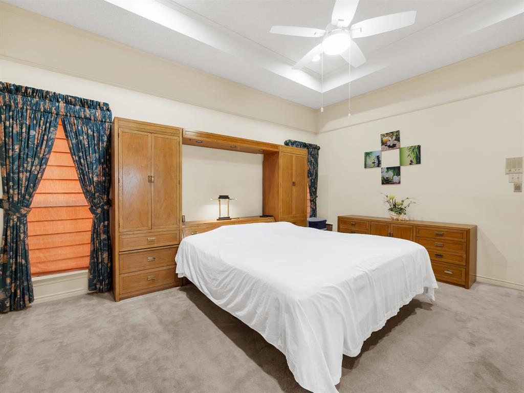 10211 Shadow Way Dallas, TX 75243 - Photo 28 of 39 a bedroom with a large bed and a chandelier