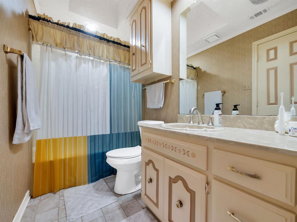 10211 Shadow Way Dallas, TX 75243 - Photo 33 of 39 a bathroom with a granite countertop sink toilet and shower