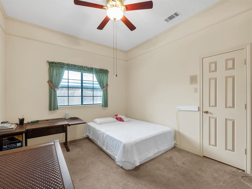 10211 Shadow Way Dallas, TX 75243 - Photo 34 of 39 a bed room with a bed and a chandelier