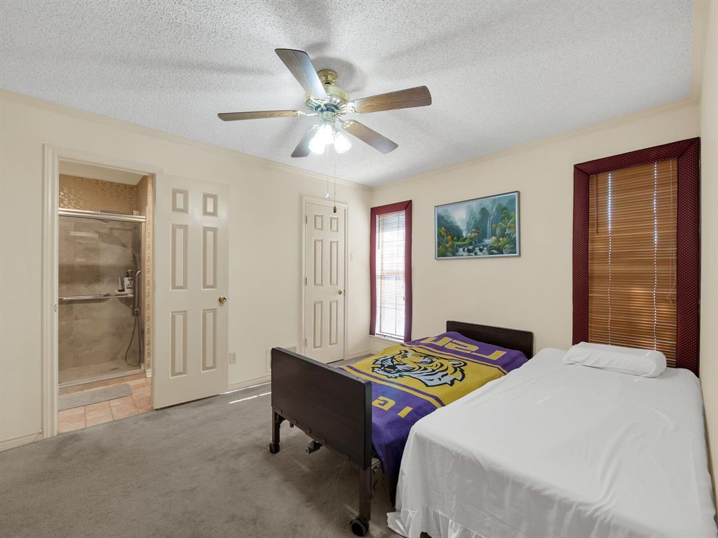 10211 Shadow Way Dallas, TX 75243 - Photo 35 of 39 a bedroom with a bed and a chandelier