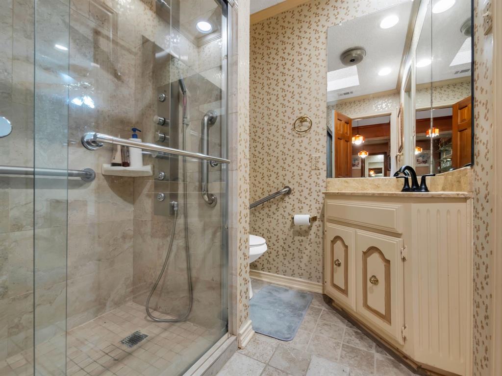 10211 Shadow Way Dallas, TX 75243 - Photo 36 of 39 a bathroom with a shower a sink and mirror