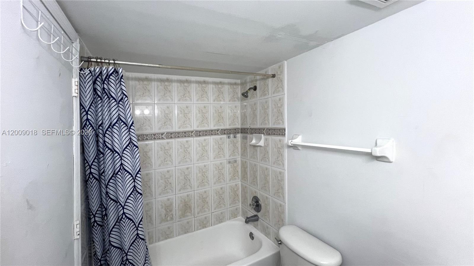666 West 81st Street, Unit 304 Hialeah, FL 33014 - Photo 14 of 21 a bathroom with a shower curtain and a bathtub